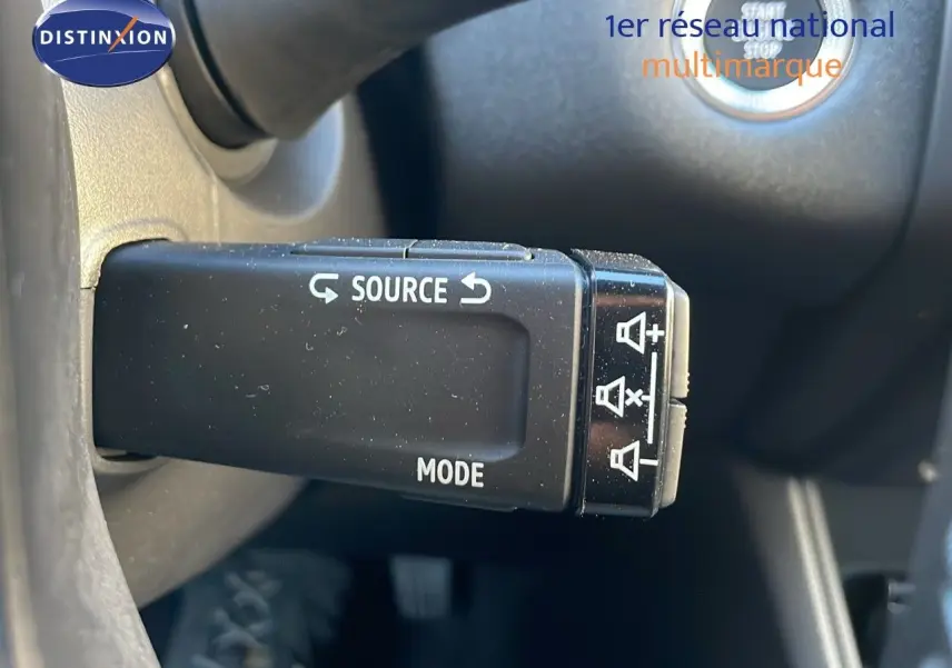 Gros plan sur la commande au volant du Renault Captur E-Tech Hybrid 2025, avec bouton source et mode visible.