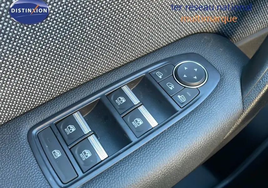 Gros plan sur les commandes des vitres électriques et rétroviseurs côté conducteur d'un Renault Captur 2025 bleu Iron Metal toit noir.