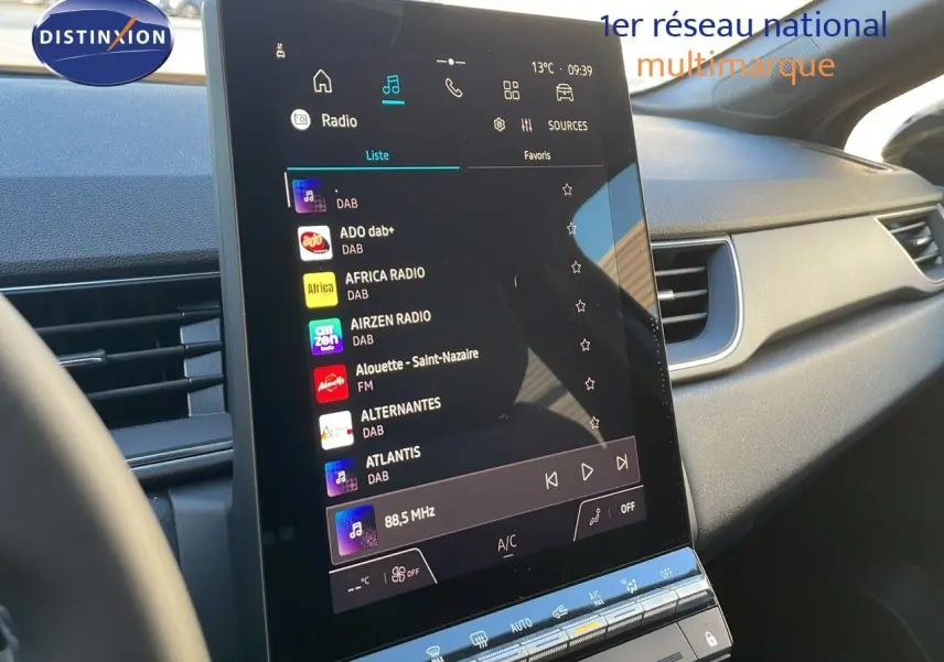 Vue intérieure du tableau de bord du Renault Captur E-Tech Hybrid 2025, écran tactile central affichant les radios DAB.