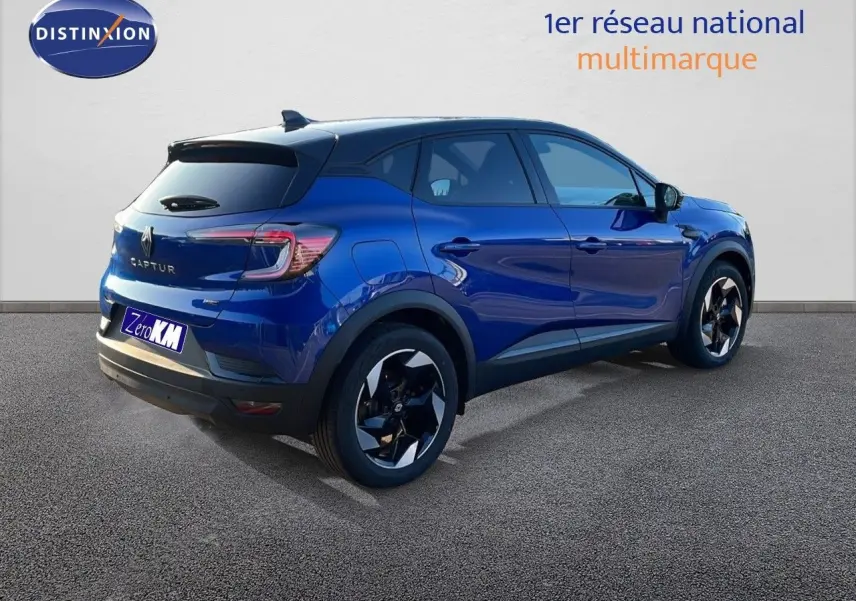 Renault Captur E-Tech hybride 2025 bleu iron avec toit noir, vu de l'arrière côté droit en extérieur.