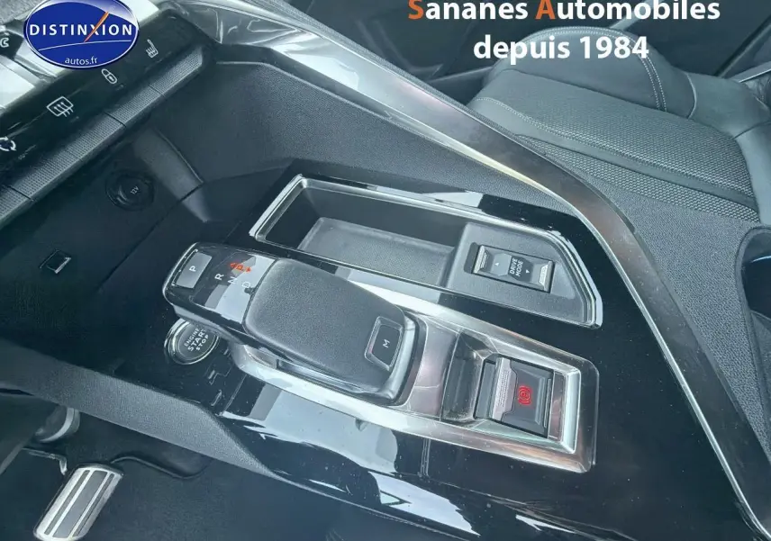 Gros plan sur la console centrale noire brillante du Peugeot 3008 GT Pack Black avec levier de vitesse automatique.