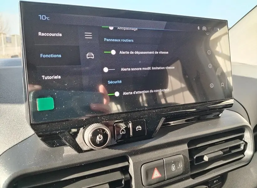 Écran tactile central du Peugeot Rifter 2025 affichant les alertes de sécurité, avec commandes et aérateurs en dessous.