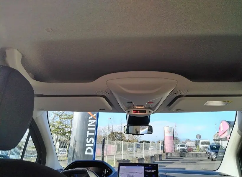 Vue intérieure avant du Peugeot Rifter 2025 avec tableau de bord et rétroviseur central, ciel de toit clair visible.