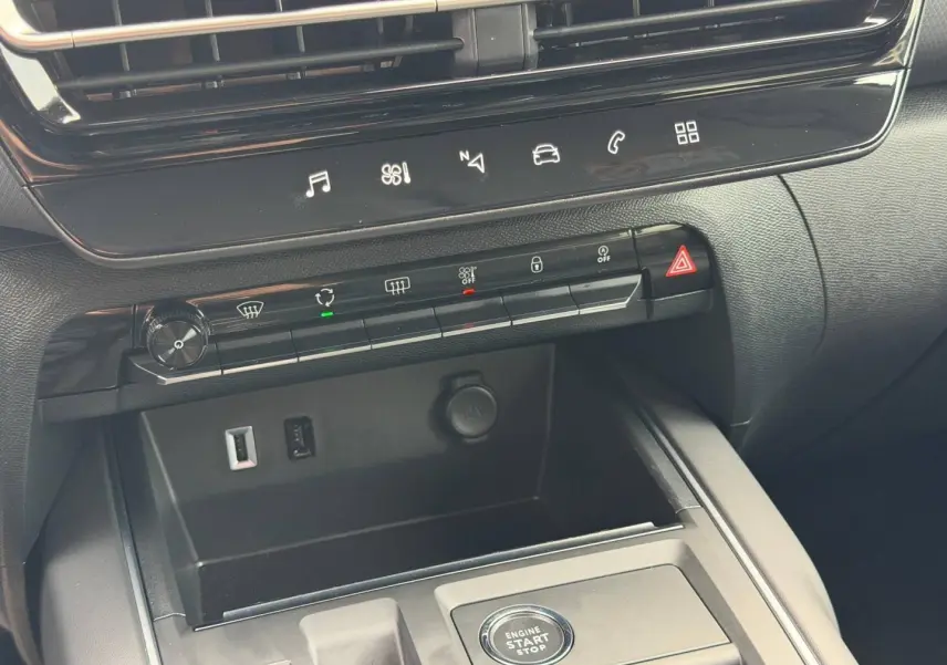 Vue rapprochée de la console centrale noire du Citroën C5 Aircross 2025 avec boutons de commande et prises USB visibles.