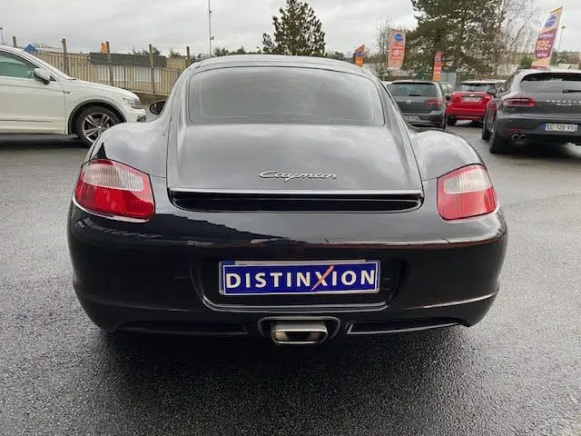 Vue arrière d'une Porsche Cayman noire de 2008 avec logo distinctif et plaque d'immatriculation personnalisée Distinxion.