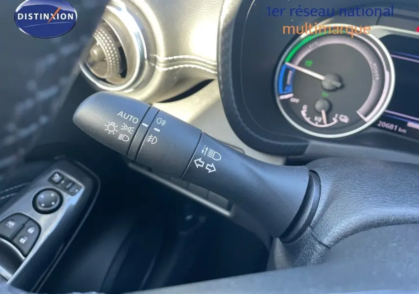 Gros plan sur la manette des phares et clignotants à gauche du volant dans l'habitacle du Nissan Juke gris 2024.