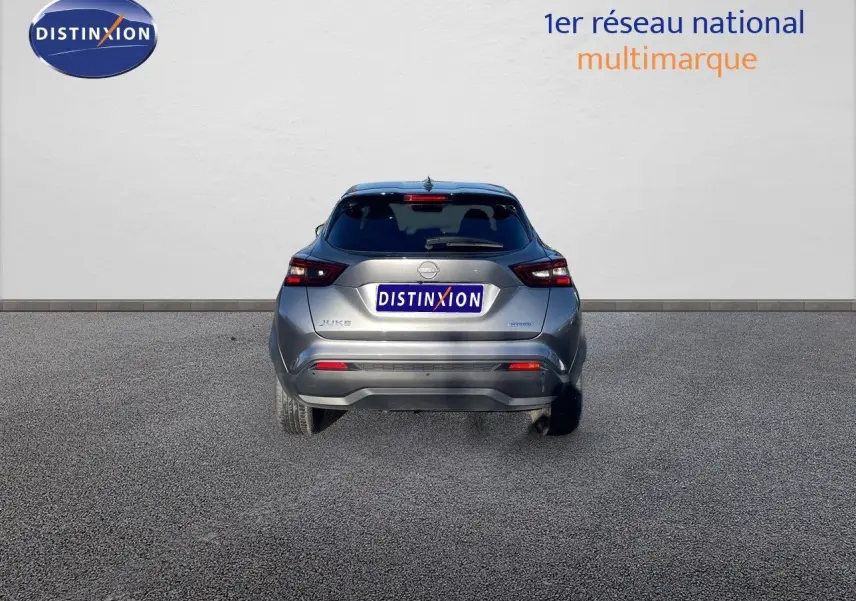 Vue arrière d'un Nissan Juke 1.6 HEV gris squale métal, mettant en valeur ses feux arrière et son design compact.
