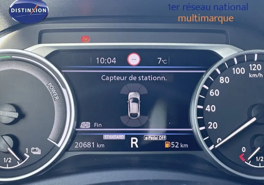 Tableau de bord du Nissan Juke gris squale métal 2024, affichant le capteur de stationnement et la vitesse à l'arrêt.