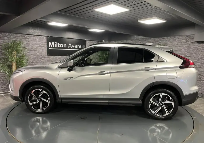 Profil côté gauche du Mitsubishi Eclipse Cross gris métallisé 2022 avec jantes alliage bi-ton et vitres surteintées.