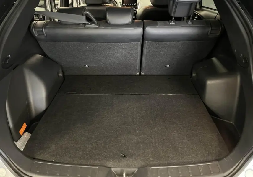 Coffre ouvert du Mitsubishi Eclipse Cross gris, vue arrière montrant banquette arrière et espace de chargement noir.