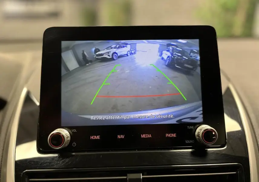 Écran tactile du Mitsubishi Eclipse Cross 2022 montrant la caméra de recul avec vue arrière sur parking intérieur.