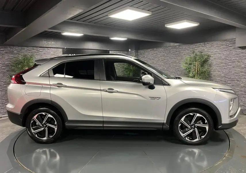 Profil droit du Mitsubishi Eclipse Cross gris métallisé 2022 hybride rechargeable avec jantes alliage bi-ton et vitres surteintées.
