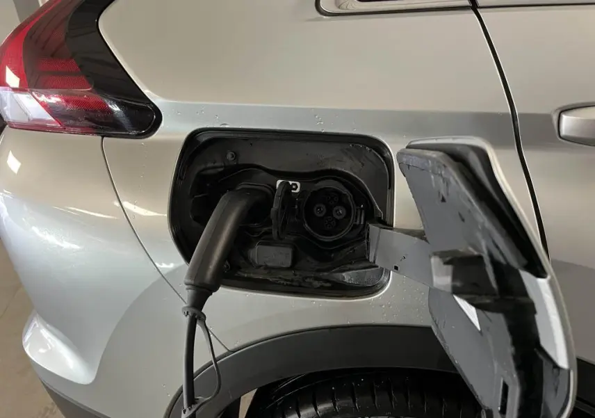 Prise de recharge branchée sur le côté gauche arrière d'un Mitsubishi Eclipse Cross gris métallisé 2022 hybride rechargeable.
