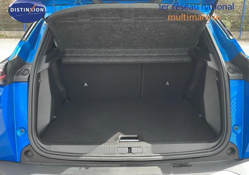 Coffre ouvert en vue arrière d'un Peugeot 2008 1.2 PureTech bleu Vertigo Métal, montrant un espace de chargement vide.