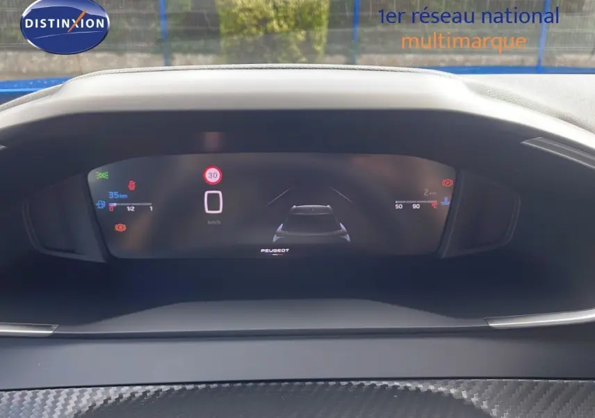 Vue rapprochée du tableau de bord numérique du Peugeot 2008 bleu Vertigo Metal, affichant la vitesse et l'autonomie.