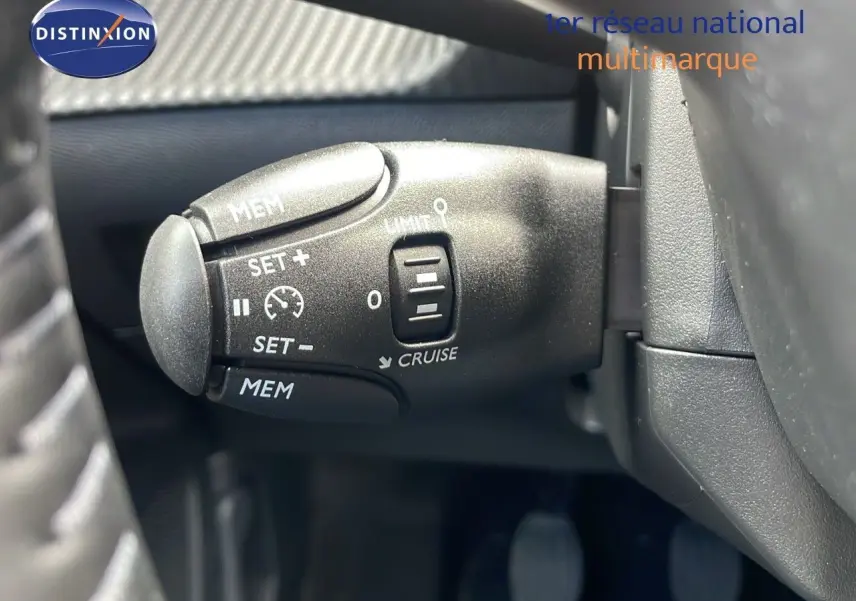 Gros plan sur la commande de régulateur de vitesse au volant d'une Peugeot 2008 2024 bleu Vertigo Metal.