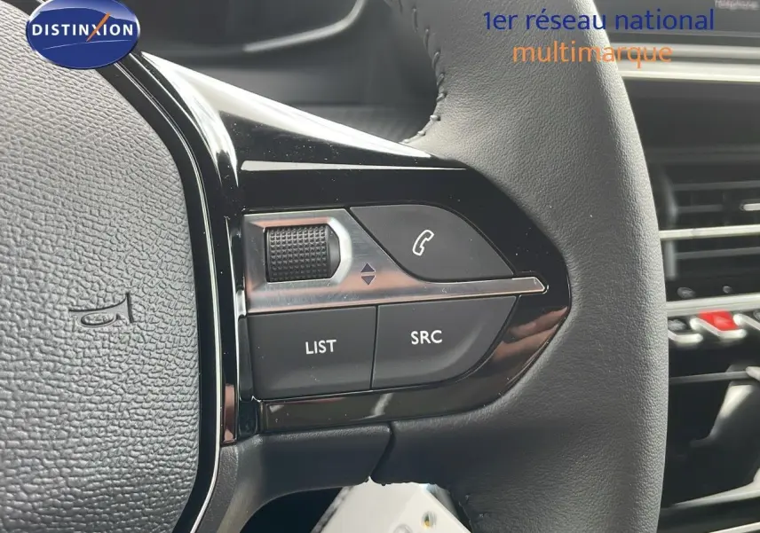 Gros plan sur les commandes au volant en cuir noir du Peugeot 2008 2024, version Allure, essence bleu Vertigo Metal.