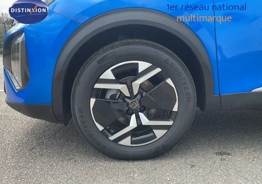 Gros plan sur la roue avant gauche d'un Peugeot 2008 bleu Vertigo Métal avec jante noire et argentée.