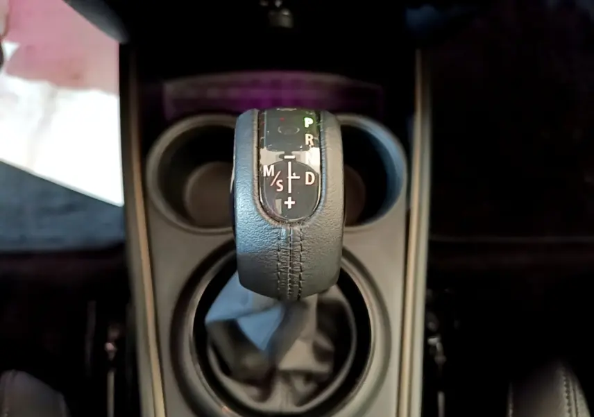 Le levier de vitesses automatique en cuir noir vu de dessus dans le MINI Countryman vert hybride 2023.