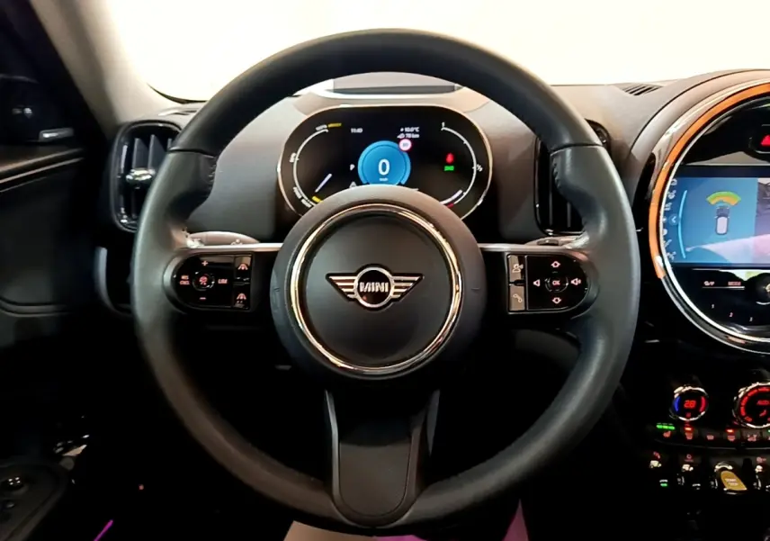 Vue intérieure centrée sur le volant cuir noir d'une MINI Countryman 2023 avec tableau de bord numérique et écran tactile.