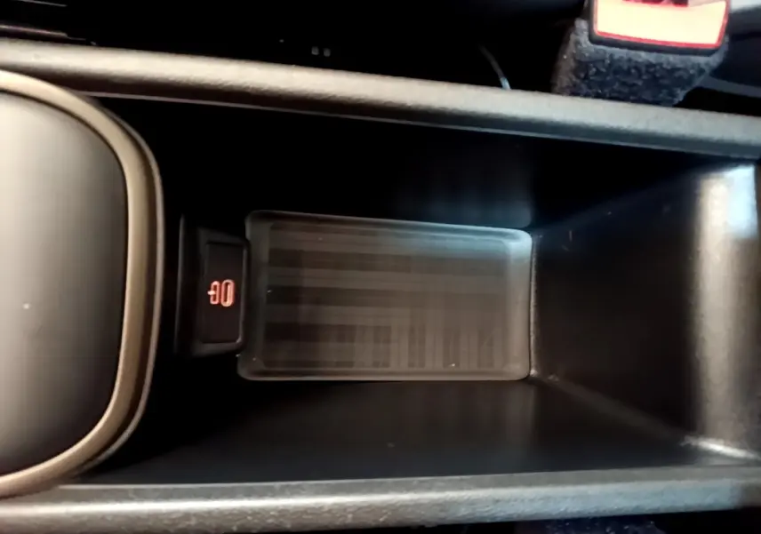 Zone de recharge par induction noire dans la console centrale du MINI COUNTRYMAN Cooper SE 2023, vue de dessus.