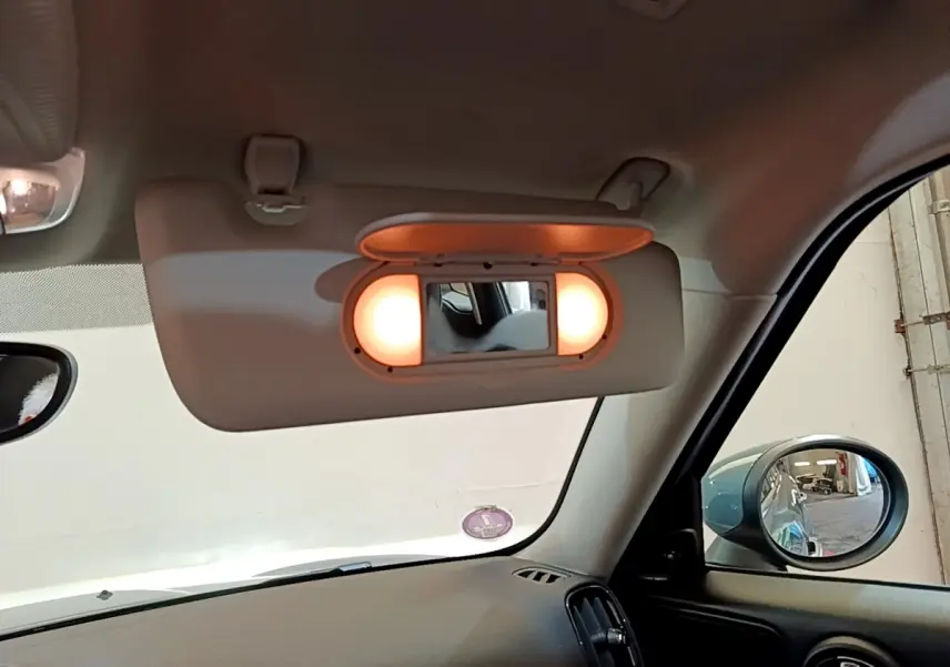 Miroir de courtoisie éclairé sur pare-soleil côté conducteur dans l'habitacle d'une MINI Countryman 2023 verte