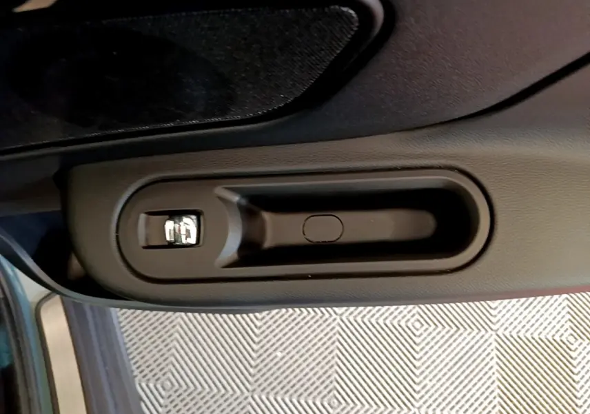 Poignée intérieure côté gauche de la MINI Countryman hybride rechargeable verte, vue rapprochée sur la commande de verrouillage.