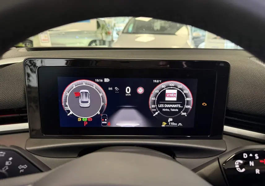 Vue intérieure du tableau de bord numérique du Volkswagen T-Roc noir intense, affichant la vitesse et la radio.