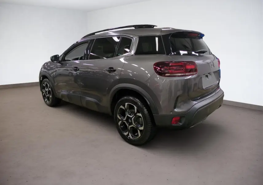 Vue 3/4 arrière droite du Citroën C5 Aircross Hybrid gris Platinium avec jantes alliage bi-ton et toit noir.