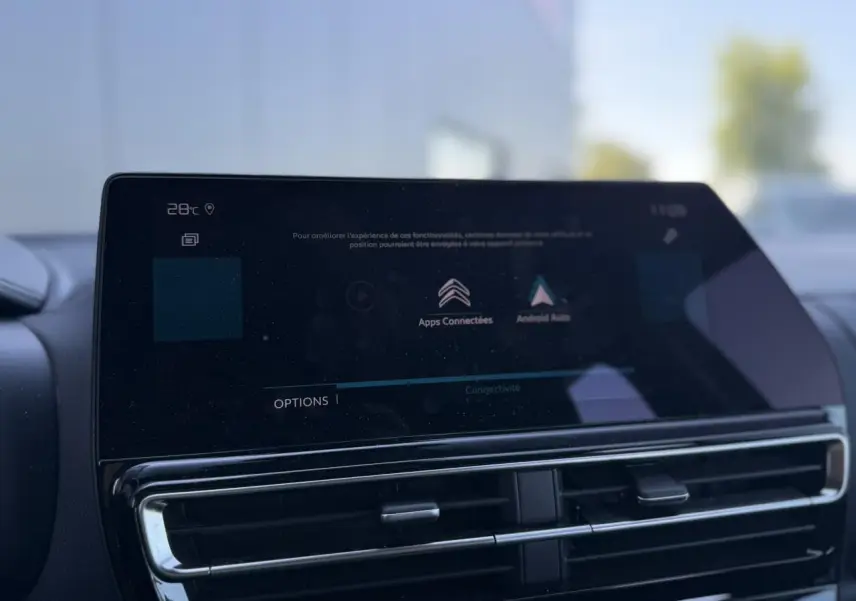 Gros plan sur l'écran tactile central et les aérateurs du tableau de bord du Citroën C5 Aircross Hybrid gris Platinium.