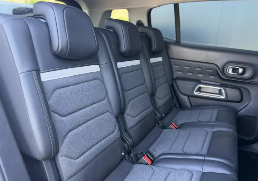 Vue latérale des trois sièges arrière indépendants en tissu et cuir noir du Citroën C5 Aircross Hybrid 2025.