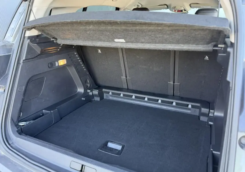 Coffre ouvert vu de l'arrière du Citroën C5 Aircross Hybrid gris Platinium, montrant la plage arrière et l'espace de chargement.