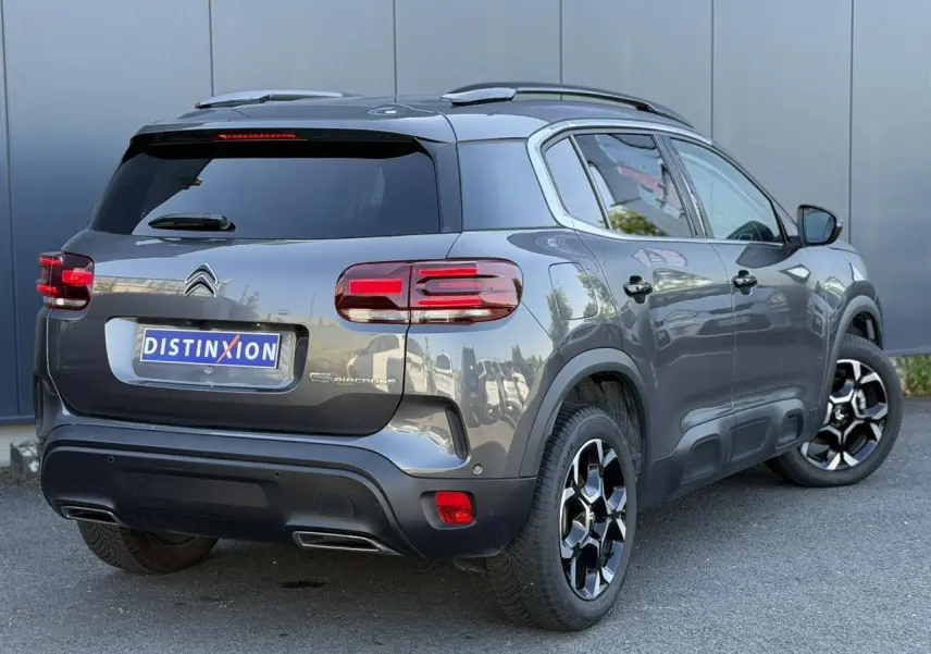 Vue 3/4 arrière droite d'un Citroën C5 Aircross Hybrid gris Platinium avec jantes diamantées et hayon électrique.