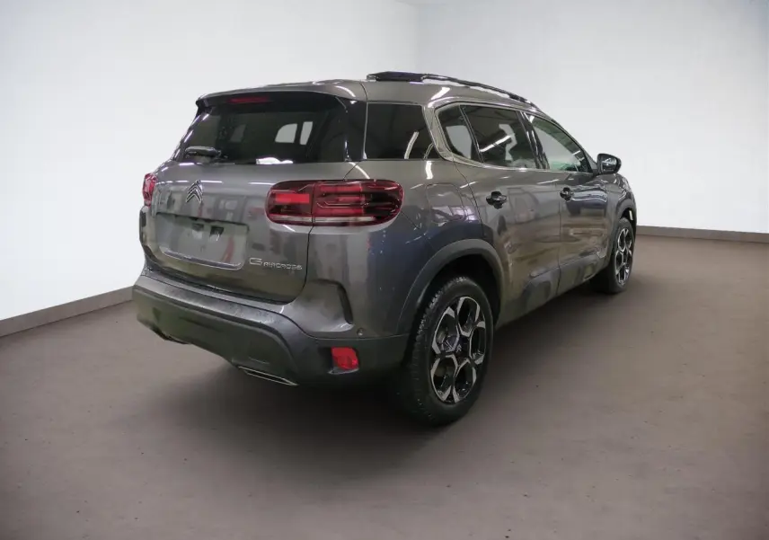 Vue 3/4 arrière droit d'un Citroën C5 Aircross Hybrid gris Platinium avec jantes alliage et hayon électrique.