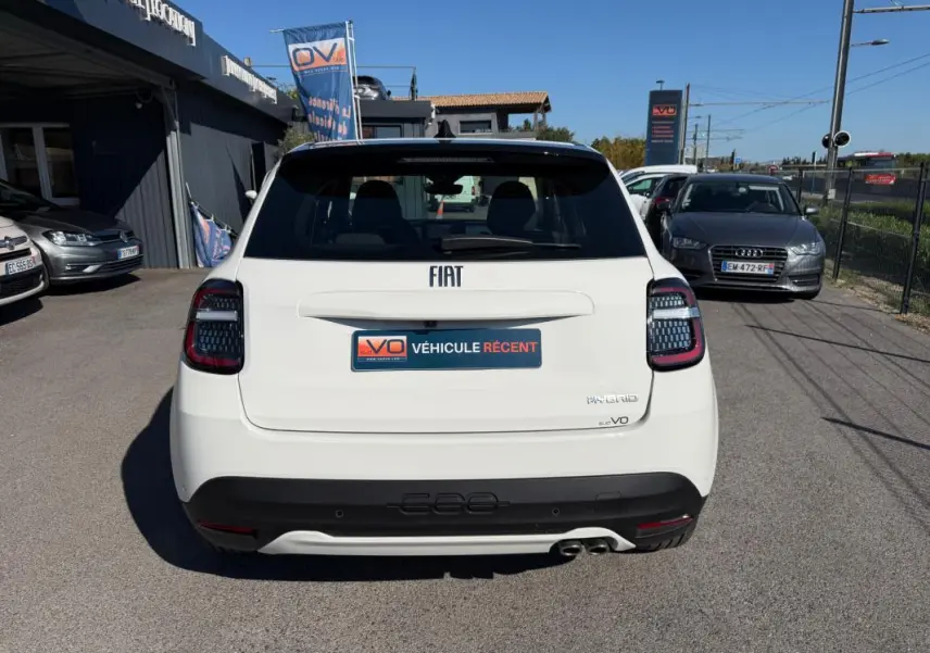 Vue arrière d'une FIAT 600 blanche 2025 avec feux arrière noirs et double sortie d'échappement visible.