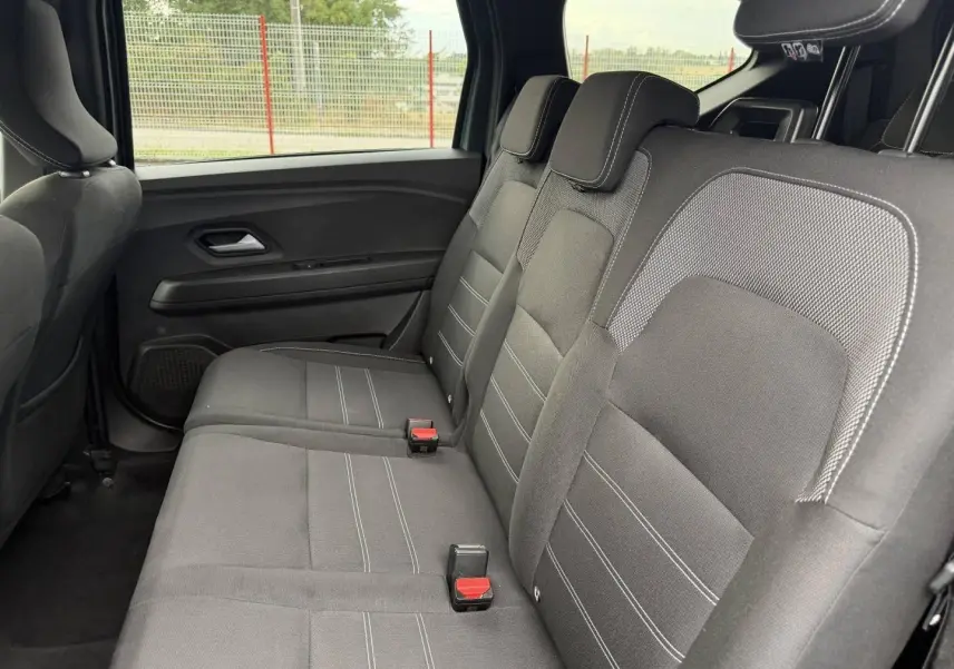 Vue latérale intérieure sur la banquette arrière noire avec appuie-têtes du Dacia Jogger 2025.