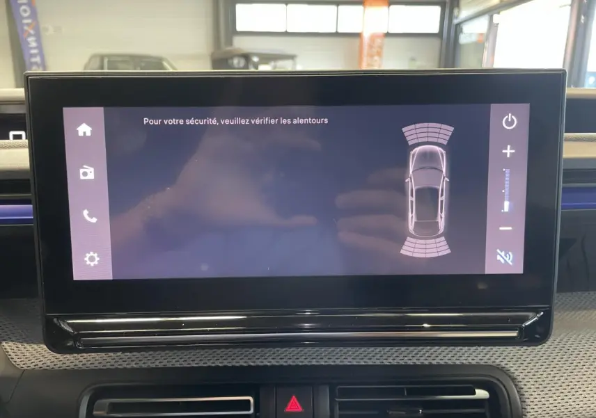 Écran tactile central affichant l'aide au stationnement dans l'habitacle d'une Citroën C3 blanche.