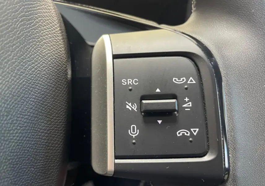 Gros plan sur les commandes au volant gauche noir mat de la Citroën C3 blanche, version 2025.