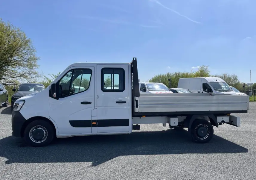 Profil droit d'un Renault Master blanc version Grand Confort avec plateau ridelles aluminium et double cabine visible.
