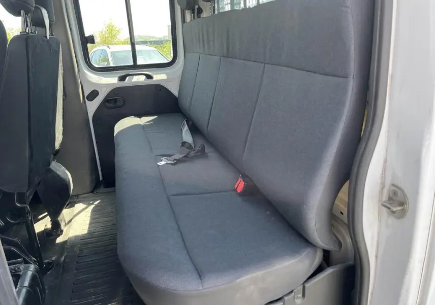 Vue intérieure côté droit sur la banquette arrière grise du Renault Master blanc double cabine avec ceintures visibles.