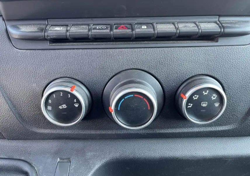 Gros plan sur les commandes de chauffage et ventilation du tableau de bord du Renault Master blanc, version Grand Confort 2020.