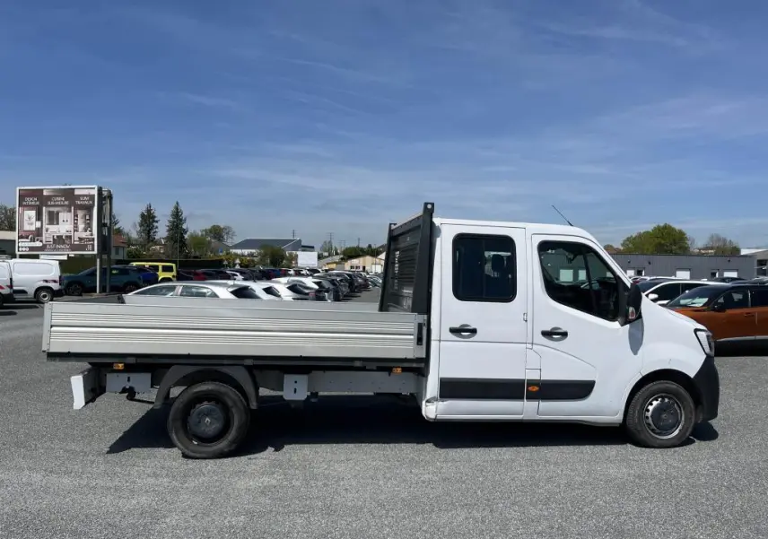 Profil droit d'un Renault Master blanc version Grand Confort double cabine avec plateau ridelles aluminium en extérieur.