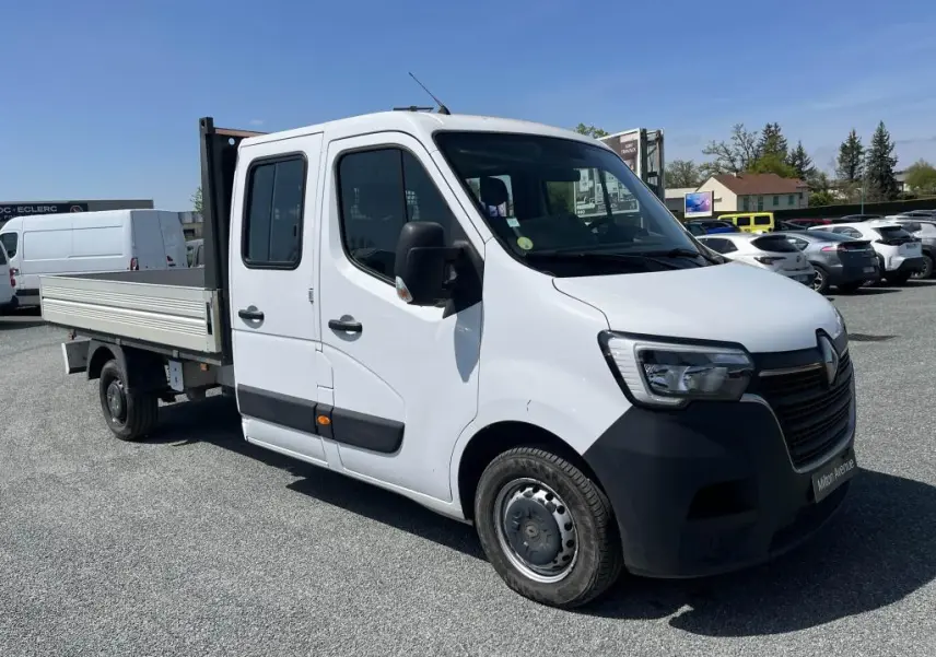 Renault Master blanc en vue 3/4 avant droit, plateau ridelles aluminium et cabine double avec quatre portes.