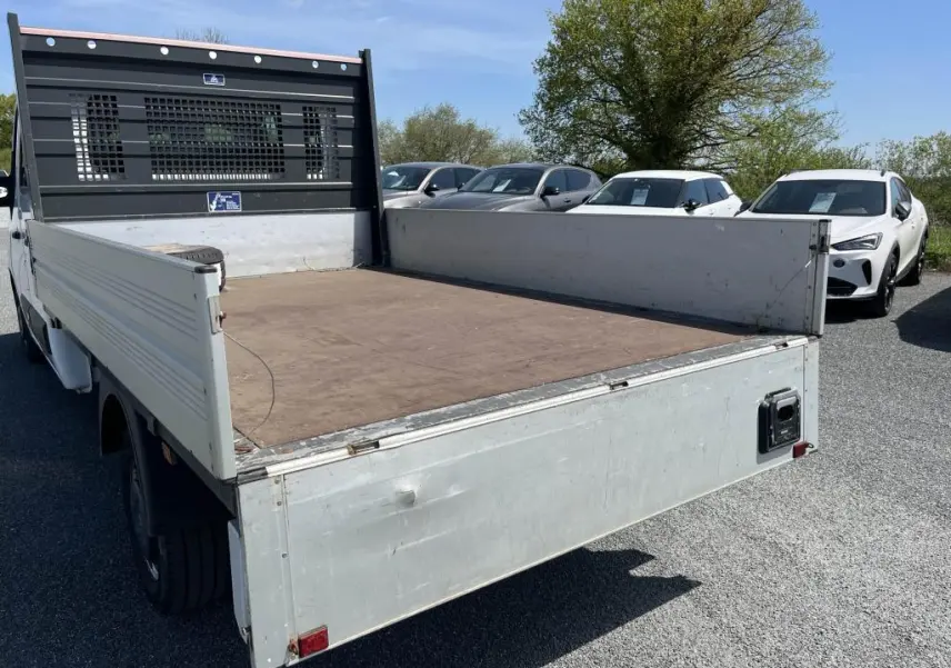Vue arrière en 3/4 gauche du Renault Master blanc avec plateau ridelles aluminium et cabine double.