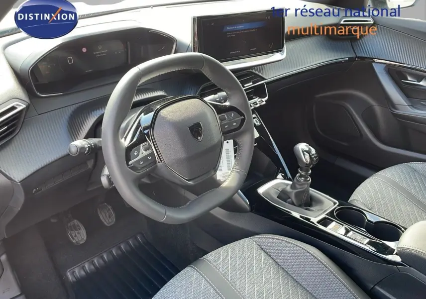 Intérieur du Peugeot 2008 2025 en gris, vue côté conducteur montrant volant compact, tableau de bord digital et levier de vitesse manuel.