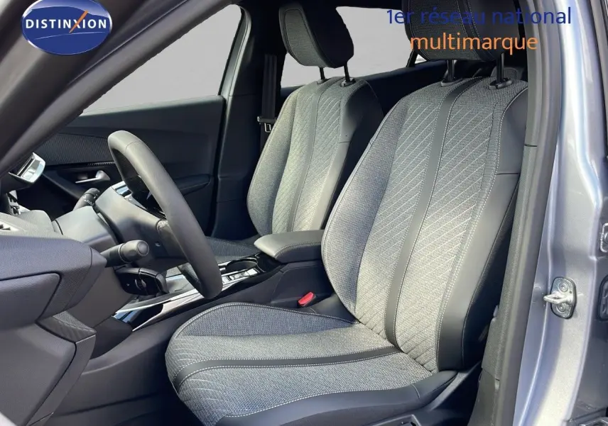 Vue intérieure côté conducteur du Peugeot 2008 gris Artense, mettant en valeur les sièges en tissu et cuir noir.