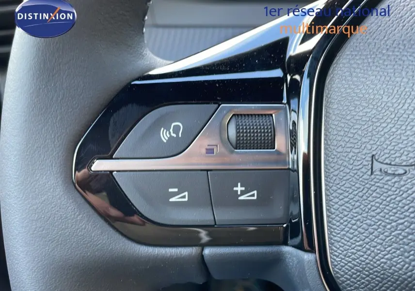 Gros plan sur les commandes de volume et appel du volant d'un Peugeot 2008 gris Artense Metal, version 2025.