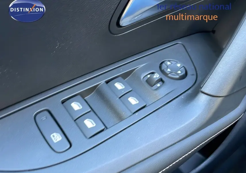Gros plan sur les commandes des vitres électriques et rétroviseurs côté conducteur du Peugeot 2008 gris Artense 2025.