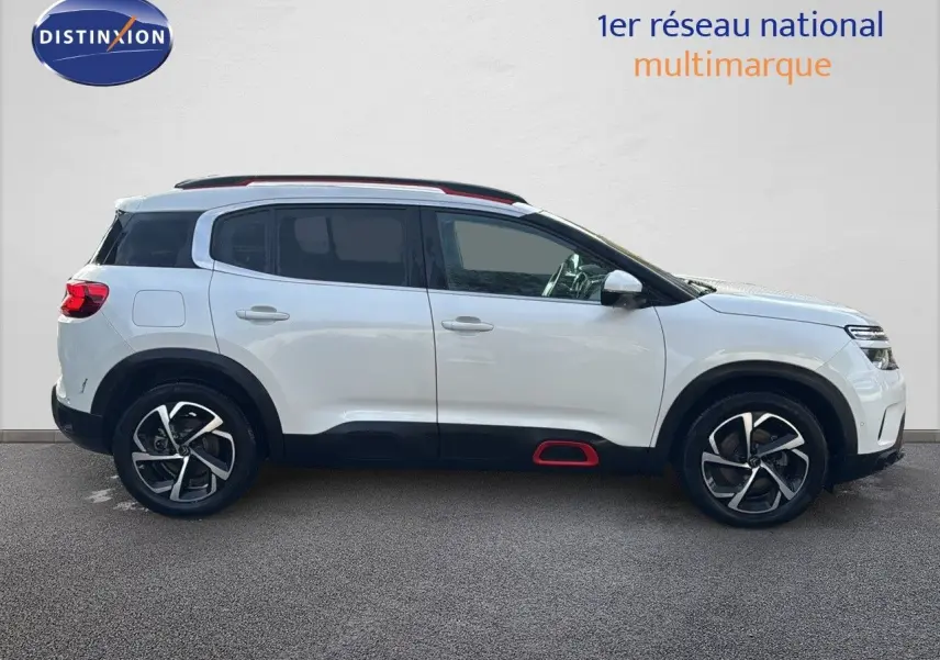 Citroën C5 Aircross blanc nacré vu de profil côté gauche, avec jantes alliage et inserts rouges sur bas de caisse.