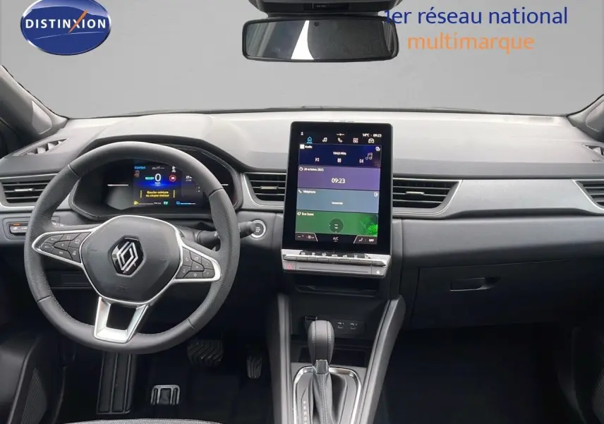 Intérieur Renault Captur E-Tech 2025 vu de face, tableau de bord moderne avec écran tactile vertical et volant multifonction.